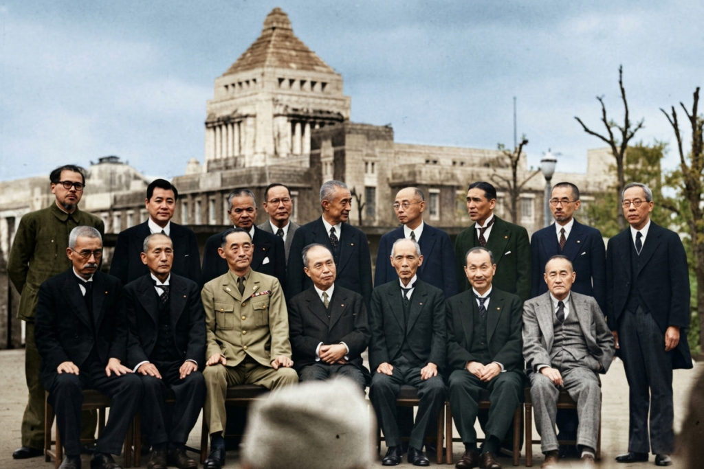 国会議事堂を背景に整列する幣原喜重郎内閣の閣僚たち。中央に幣原首相、その周囲に軍服やスーツ姿の閣僚が座っている。